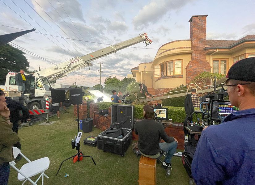 A production crew working outside on a television commercial set