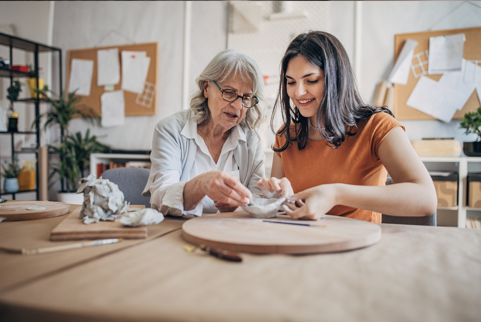 Teenage girl and older woman making pottery