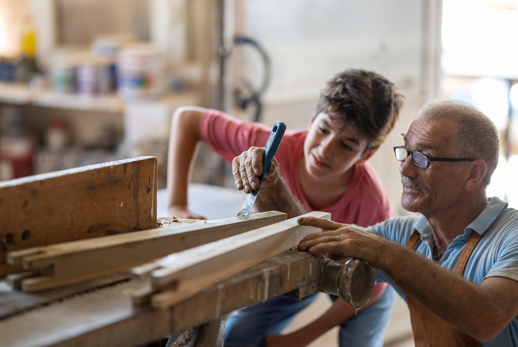 Young boy and older man in wood workshop