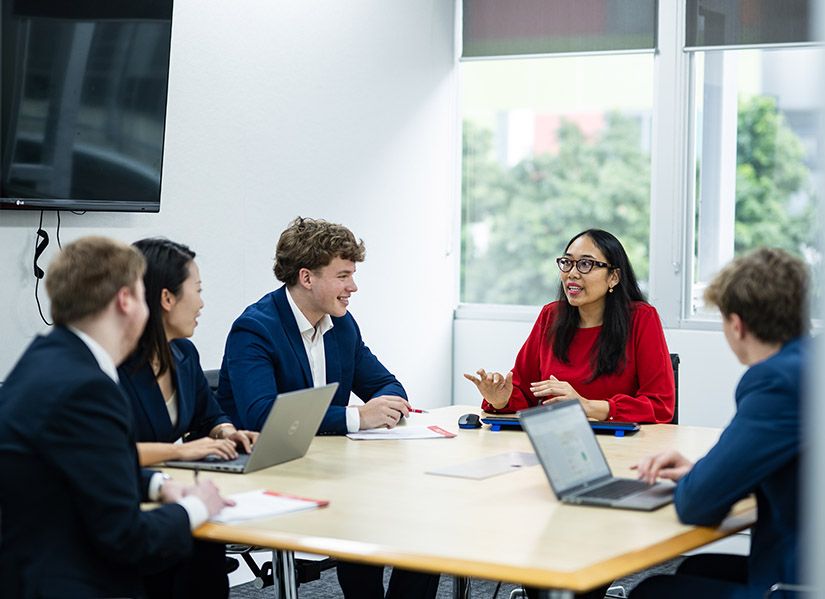 PRD Real Estate employees sitting around table in meeting room